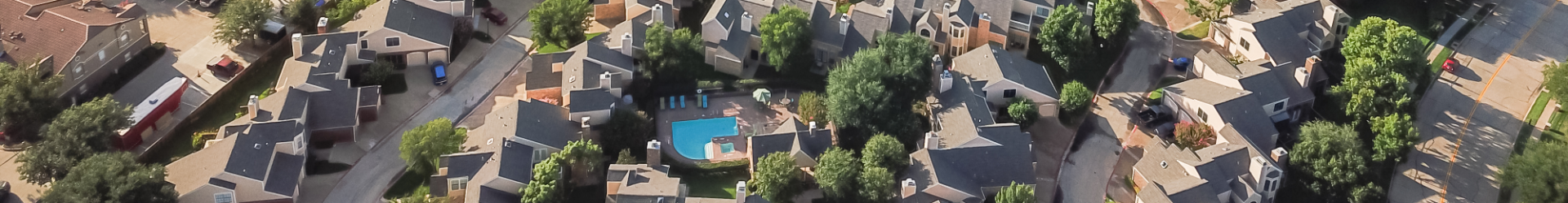 drone shot of neighborhood with pool in one backyard